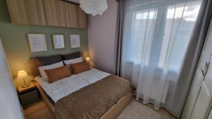 格但斯克Apartament Młody Gdańsk - bezpłatny parking, mocne WiFi, dobre połączenie z lotniskiem的一间小卧室,配有床和窗户