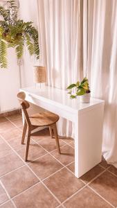 维拉韦德Siempre Feliz La Casita Los Molinos的一张带椅子和植物的白色书桌