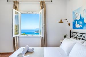 斯科派洛斯Liagka Villa的一间卧室设有一张床和一个海景窗户