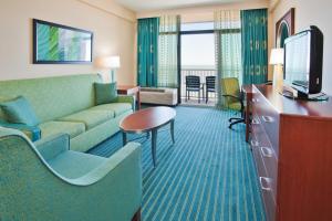 弗吉尼亚海滩Holiday Inn & Suites Virginia Beach - North Beach, an IHG Hotel的一间配备有沙发及电视的酒店客房