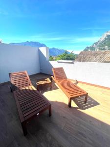 加尔达湖滨Garda Family & Solarium的两把木椅,坐在山景阳台上