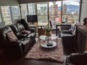 温哥华Vancouver Downtown Accommodation的带沙发和桌子的客厅以及大窗户。