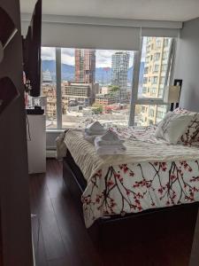 温哥华Vancouver Downtown Accommodation的一间卧室设有一张床和一个大窗户