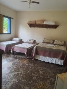 ItapecericaHotel Fazenda Palestina的带三张床和窗户的客房
