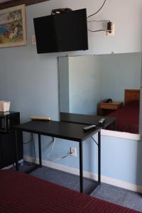 兰伯顿经济汽车旅馆的一张黑色的桌子,墙上配有平面电视
