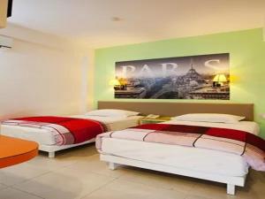 玛琅Dewarna Hotel Arifin的墙上画画的房间里设有两张床