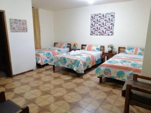 伊瓦拉Hostal Cumbres Andinas的一间房间,有三张床