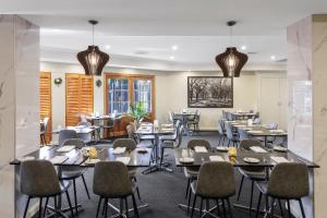 墨尔本墨尔本机场品质酒店的一间在房间内配有桌椅的餐厅