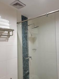 伊纳南TD CAPITAL HOTEL的带淋浴的浴室和玻璃门
