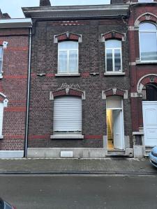 列日Grande maison avec plusieurs chambres à louer的街道上设有白色车库门的砖砌建筑