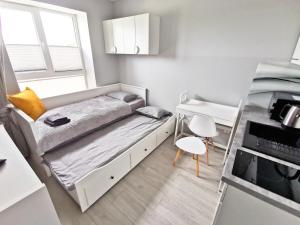 格丁尼亚Apartamenty Fińska Gdynia的一间小卧室,配有一张床和一张书桌