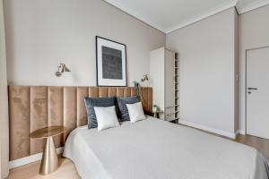 格但斯克Grand Apartments - Brabank Premium apartament w centrum Gdańska的一间卧室配有一张大床和木制床头板