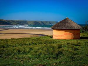 BulunguluBulungula Xhosa Community Lodge的海滩旁的小屋