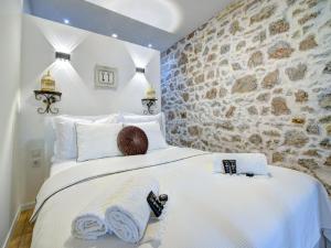 塞尼History House Moja Ti 1830 in Old Town Senj的卧室配有一张白色大床和石墙