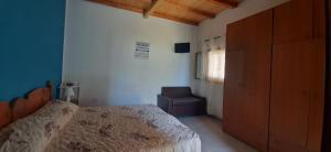 兰佩杜萨Lampedusa Casa a 3 passi di Cala Madonna的一间卧室配有一张床和一把椅子
