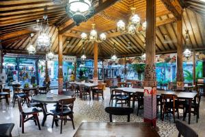 海神庙Dewi Sinta Hotel and Restaurant的餐厅内带桌椅的用餐室