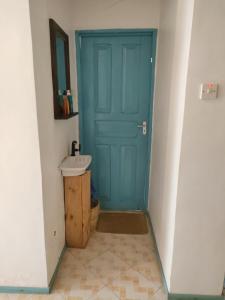 帕杰Déjà Blue的浴室设有蓝色门和水槽