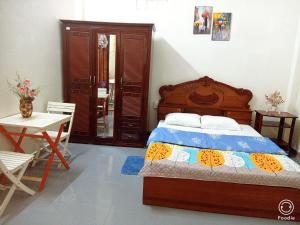 Hiếu XươngNoel Homestay的卧室配有1张床、1张桌子和1把椅子