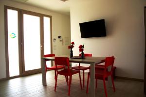 阿莱齐奥Eco Villa con piscina privata e indipendente的一间带桌子和红色椅子的用餐室