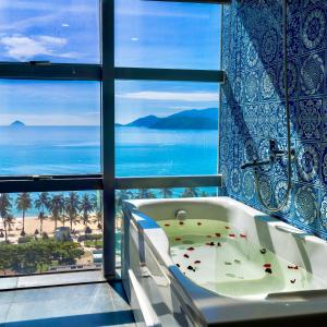 芽庄Prime New Hotel的带浴缸的浴室,享有海景。