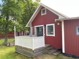 龙讷比Aspan Kurs & Lägergård的红色的房子,设有白色门廊和白色阳台