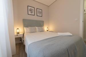 洛格罗尼奥Apartamento el centro的卧室配有一张白色大床和两盏灯。