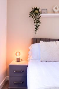 斯托克波特Stunning 1 bed apartment in the heart of Stockport的一间卧室配有一张床和一个带灯的床头柜