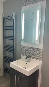 贝尔法斯特CityGo Apartments Queens Wellington的浴室设有白色水槽和镜子