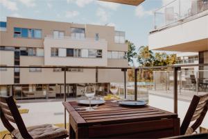 拉脱维亚New Exclusive 2BD apartment by the sea的阳台上的木桌和两杯酒杯