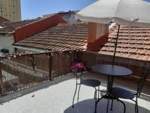 里斯本Moradia em vila da cidade的阳台配有一张桌子和两把椅子以及一把遮阳伞。