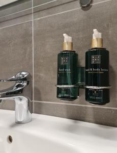 赫马万Hemavans Wärdshus的浴室水槽上放有两瓶绿的除臭剂