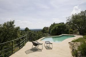 蒙罗约肯索拉松酒店的一个带两把椅子的庭院和一个游泳池