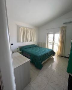 克罗托内特拉兹住宿加早餐旅馆的一间卧室设有一张绿色的床和一个窗户。