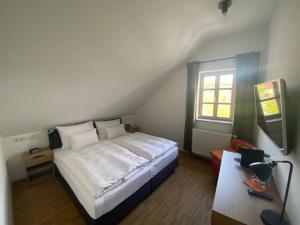 雷根斯堡Altstadthotel Alt & Jung的卧室配有白色的床和窗户。