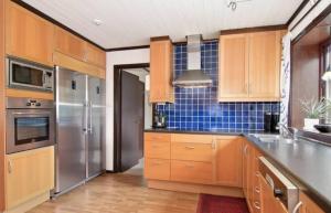 于默奥Private Room in Shared House-Close to University and Hospital-3的厨房配有木制橱柜和不锈钢冰箱。