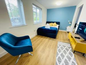凯尼尔沃思KENILWORTH STUDIO * GROUND FLOOR * PARKING的一间卧室配有蓝色的床和蓝色椅子