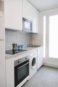 潘普洛纳Apartamento Pamplona 1的白色的厨房配有水槽和洗衣机