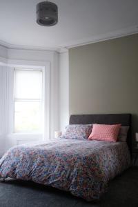 利斯本Gorgeous 3 Bedroom Victorian Townhouse的一间卧室配有一张带五颜六色的被子的床和窗户