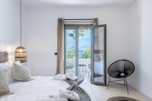 帕罗斯岛PAREA Paros - Adults Only的卧室配有白色的床和镜子