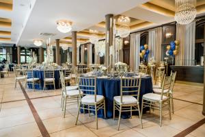 奥斯特罗维茨Hotel RED的宴会厅配有蓝色的桌椅和吊灯