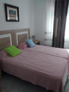 德尼亚Boutique Los Pinos的一间卧室配有一张带绿色和蓝色枕头的大床