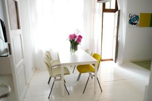 姆拉哥沃Apartamenty Mrągowo Warszawska Cudo Studio的餐桌,配有黄色椅子和花瓶
