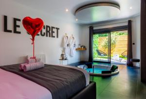 南特Le Secret - Nuit romantique avec Jacuzzi privatif - Champagne offert - Climatisation的卧室配有一张壁挂着心球的床