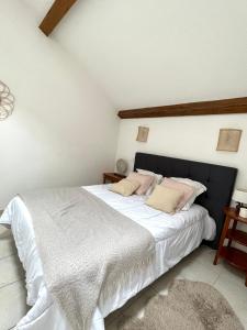 利尼翁河畔勒尚邦"Les Oiseaux" avec terrasse, parking, duplex的卧室配有一张带白色床单和粉红色枕头的大床。