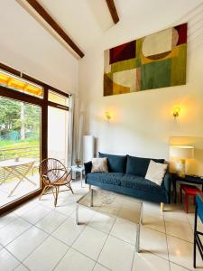 利尼翁河畔勒尚邦"Les Oiseaux" avec terrasse, parking, duplex的客厅配有蓝色沙发和绘画作品