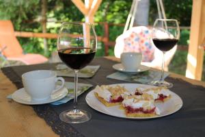 NowicaDomki w Nowicy的一张桌子,上面放着两杯葡萄酒和一盘食物