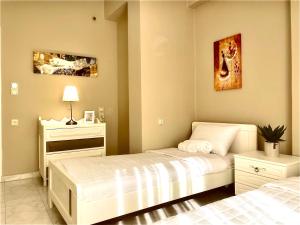 干尼亚Christina_Apt的一间卧室配有两张床、一张桌子和一张图片