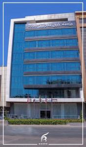 埃尔比勒Best Inn Erbil - Shorash的一座大型玻璃建筑,上面有标志