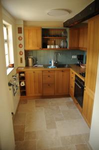 RettertFachwerkhaus的厨房配有木制橱柜和瓷砖地板。