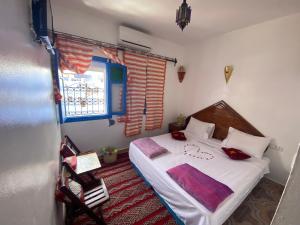 舍夫沙万Riad sakura的一间卧室配有一张带白色床单的床和一扇窗户。